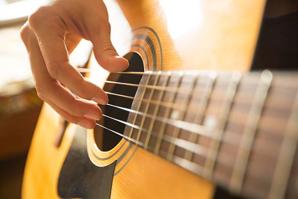istock Female hand playing on acoustic guitar 450300821
