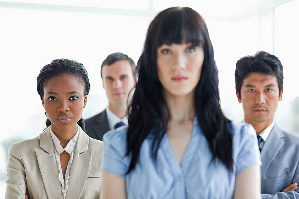 istock Three business people standing upright with their leader 450300949