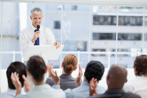 istock Businessman smiling while being applauded by a business te 450300955