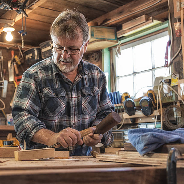 istock Craftsman Carpenter Chiseling Wood in Workshop 450303533