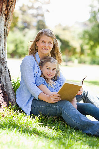 istock Mother and daughter smiling as they hold a book 450304833