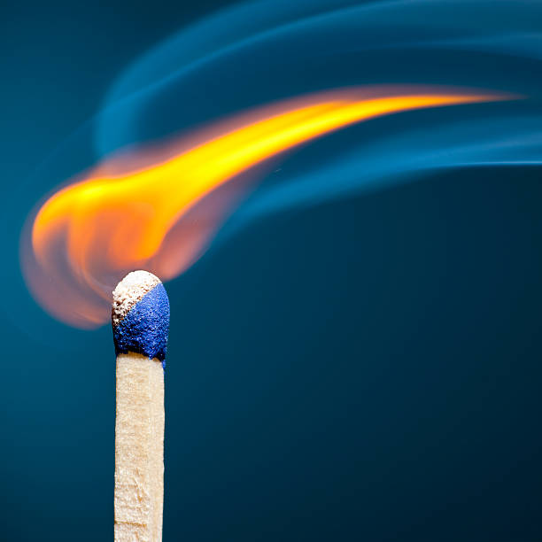 Standing, burning match on a black background