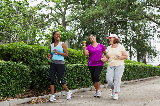 istock Three diverse women jogging in a park 450309317