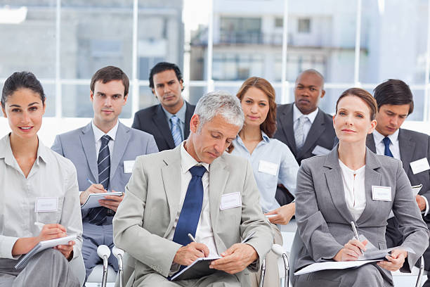 istock Businessman writing notes as he sits with his colleagues 450311181
