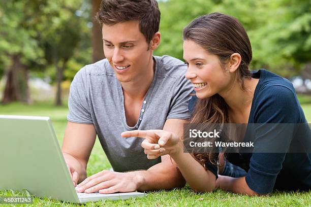 Foto de Casal Usando Um Laptop Deitado No Abdômen e mais fotos de stock de 18-19 Anos - 18-19 Anos, 20 Anos, Abdome