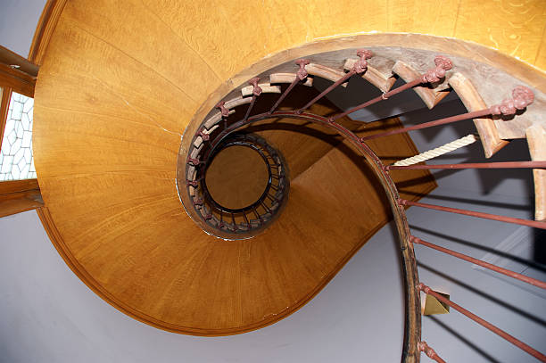 istock Spiral staircase with wooden steps in the house 450324357