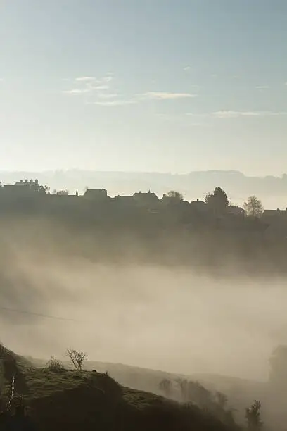 Morning mist rising from valley in Cotswolds, Rusombe and Whiteshill villages in Gloucestershire.