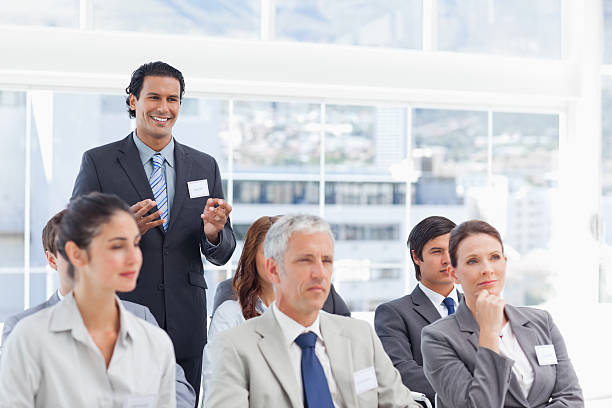 istock Smiling businessman gesturing with both hands as he stands behin 450395925