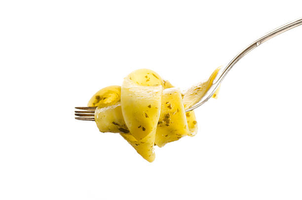 Italian pasta with pesto sauce and basil leaf on fork isolated on white