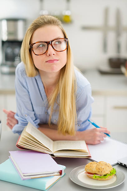 istock Thoughtful teenager girl studying in kitchen 450417641