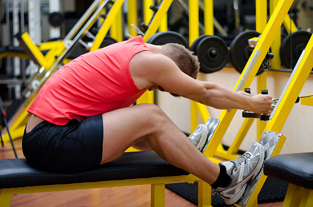istock Handsome young man working out on gym equipment 450424369