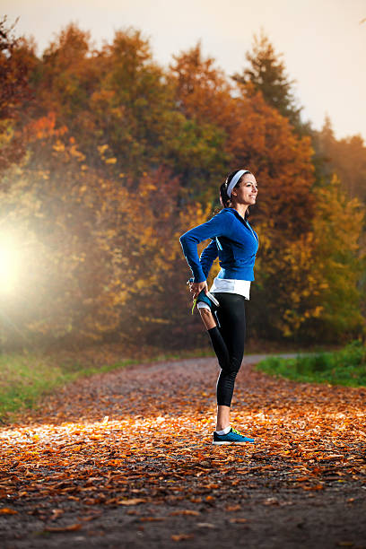 istock Young woman stretching before running in the autumn 450424909