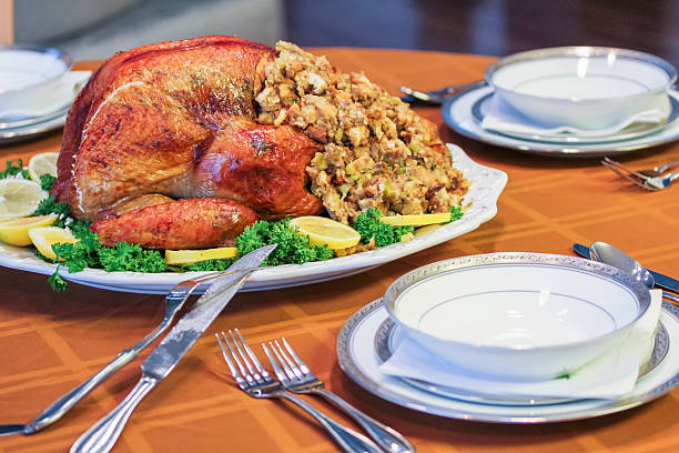 Roasted turkey on table set for Thanksgiving Roasted turkey on table set for Thanksgiving single flower flower autumn pumpkin stock pictures, royalty-free photos & images