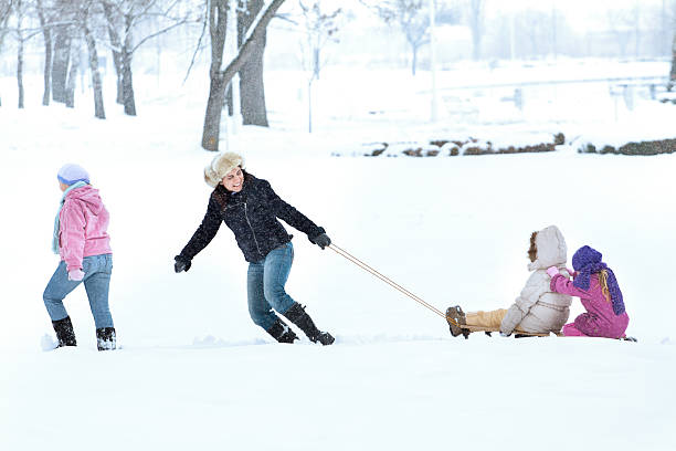 Red plastic sleigh, sledge, sled on white snowy background outdoors. Winter play and activity for kids