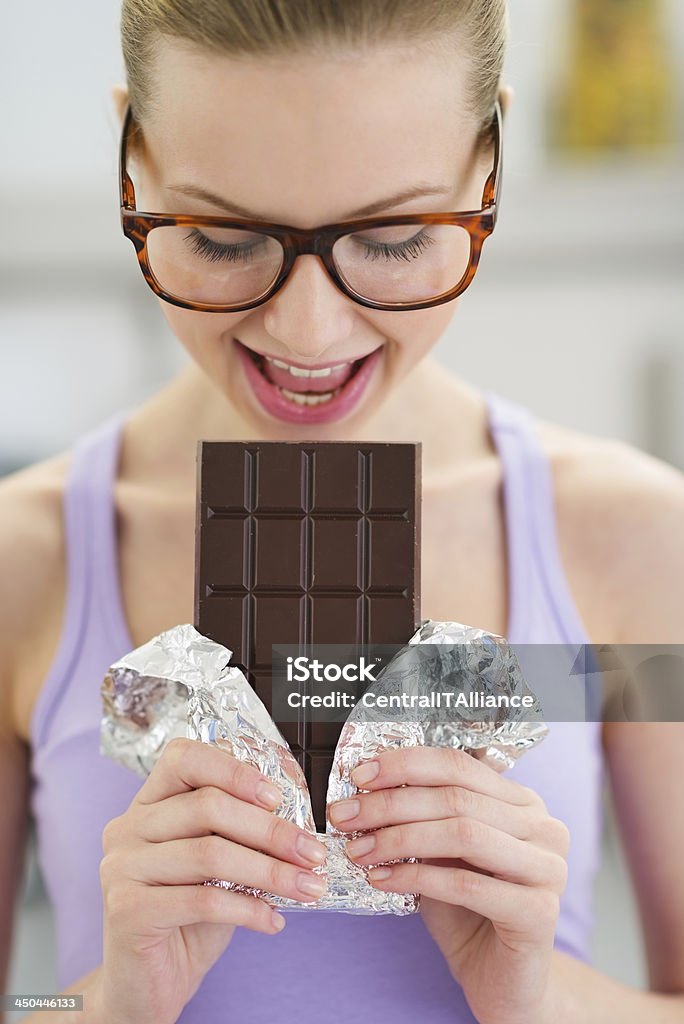 Young girl eating chocolate bar Women Stock Photo