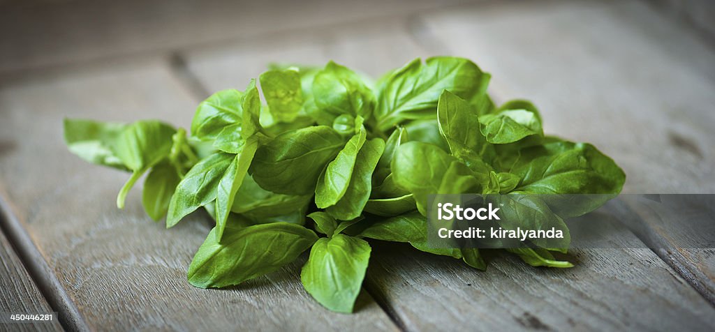 Basil leaves on a wooden table Basil Stock Photo