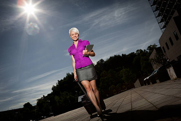 Businesswoman with trolley and tablet pc walking