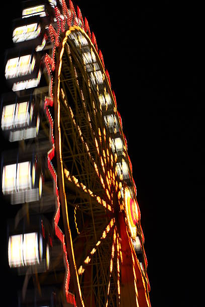 Nightly ferris wheel Rotating nightly ferris wheel at the "Hamburger Dom". gyration stock pictures, royalty-free photos & images