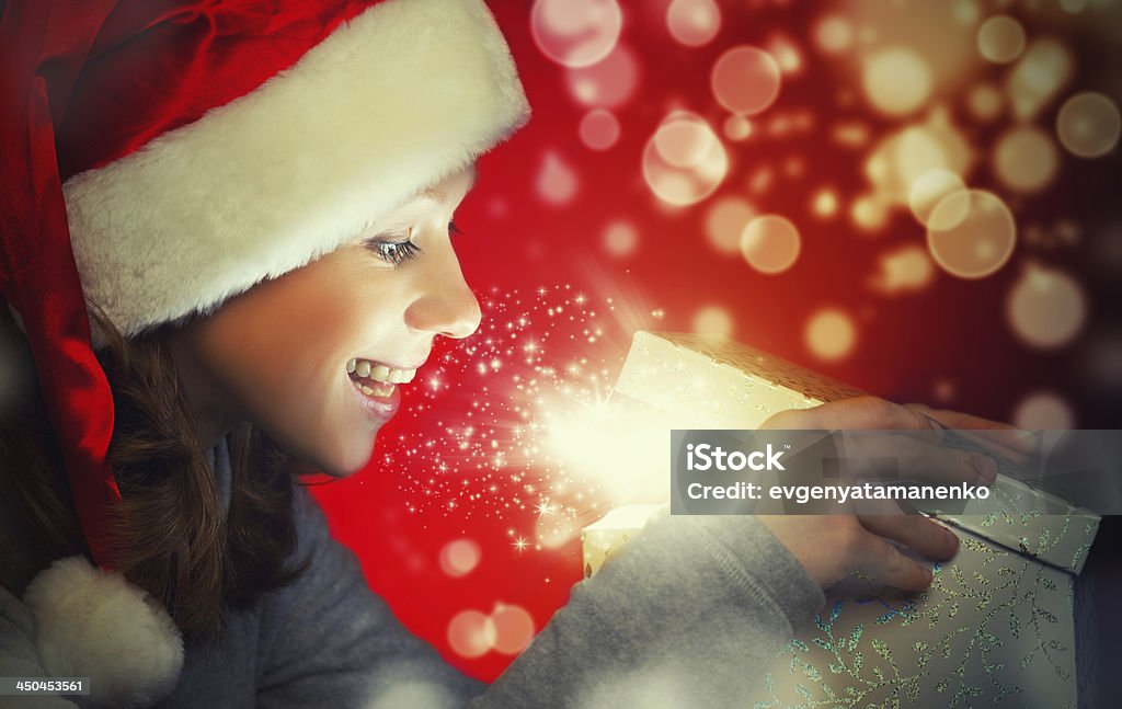 Feliz mulher em um boné de Natal Abre a caixa mágica - Foto de stock de Abrindo royalty-free