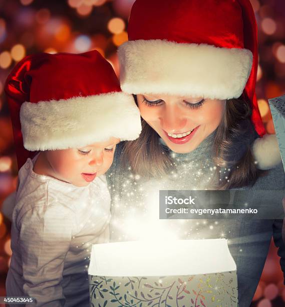 Foto de Caixa Mágica Presente De Natal E Um Feliz Família Mãe De Bebê e mais fotos de stock de Abrindo