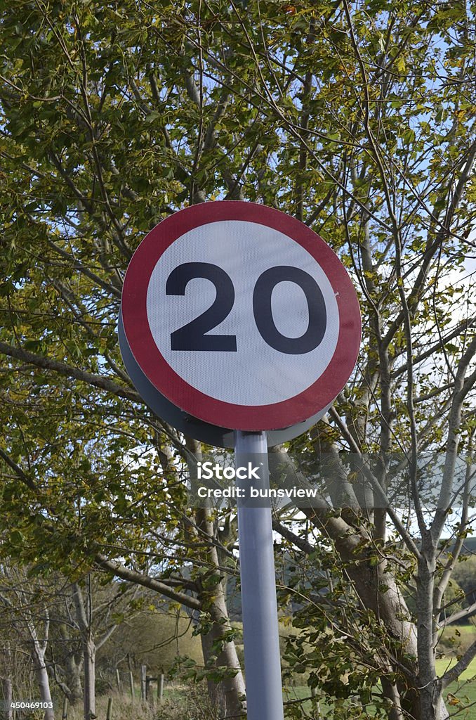 Speed Restriction Sign A 20MPH roadside speed restriction sign. Bush Stock Photo