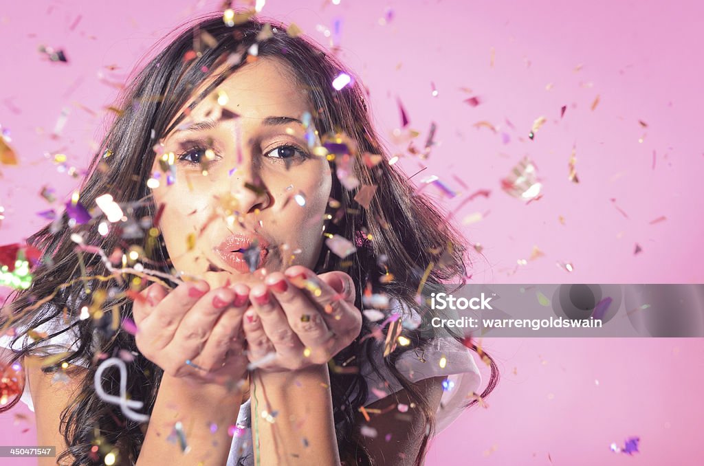 Woman blowing colourful confetti Portrait of beautiful woman blowing confetti in the air, party new years eve celebration on pink background Women Stock Photo