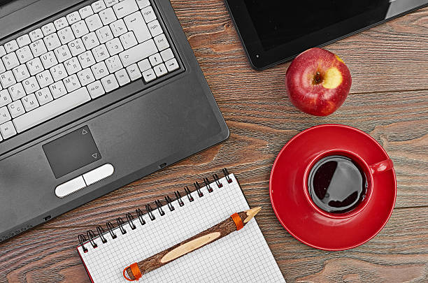 istock Laptop and office supplies on wooden table 450473823