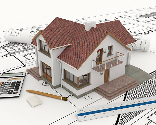 istock 3D building house with blue prints under and tools to draw 450474135