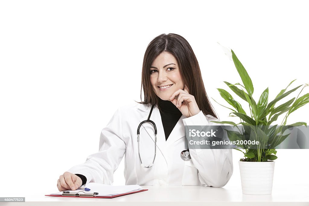 Feminino médico sentado na sua mesa - Foto de stock de Adulto royalty-free