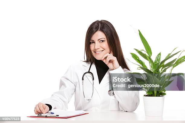 Feminino Médico Sentado Na Sua Secretária - Fotografias de stock e mais imagens de Adulto - Adulto, Clínica médica, Cuidados de Saúde e Medicina
