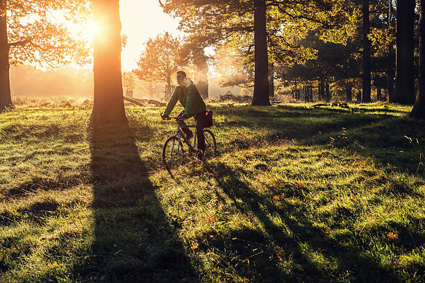 young man cycling in Richmond Park, London in the morning