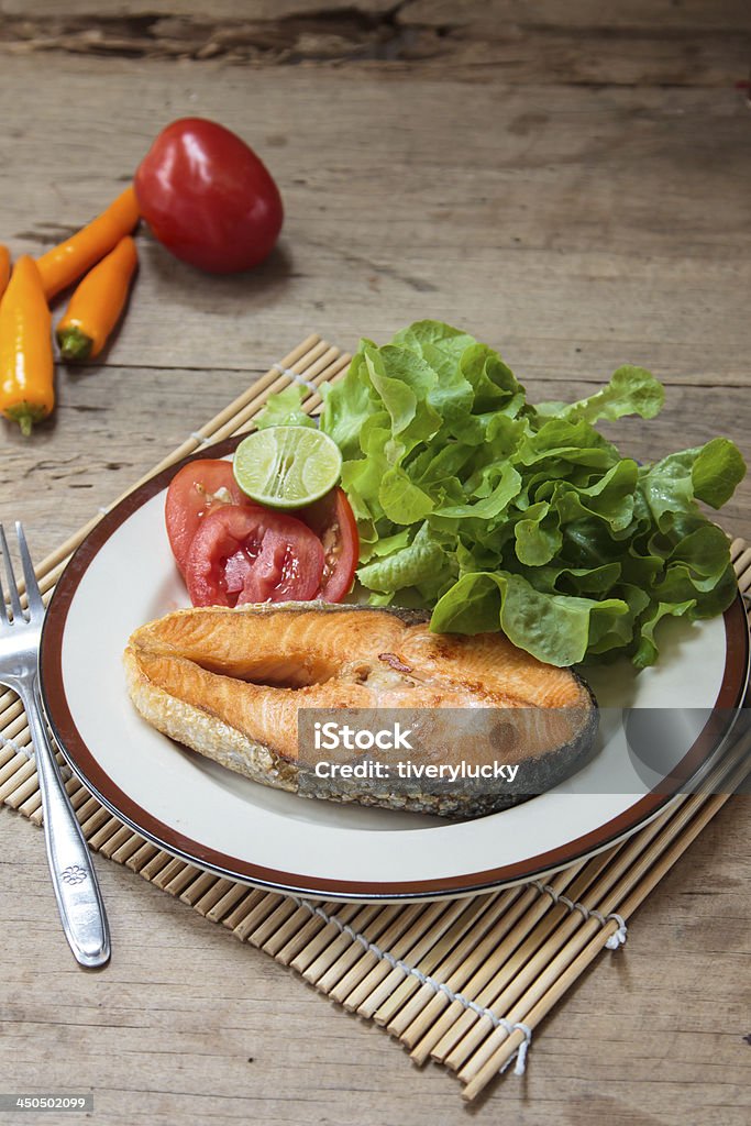 Trancio di salmone su un tavolo di legno - Foto stock royalty-free di Arrosto - Cibo cotto