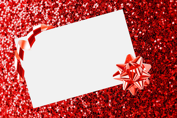 istock Christmas sheet of paper with bow on red defocused background 450502255
