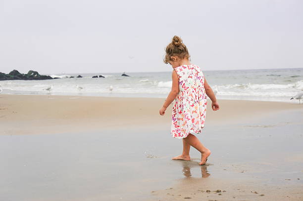 istock Little two year old girl at the beach 450531157