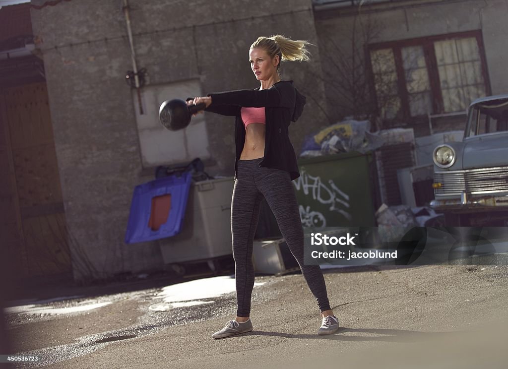 Having Toned Body Requires Hard Work Young fitness woman swinging the kettle bell during gym training Abdominal Muscle Stock Photo