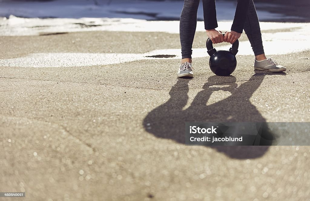 Shadow of a trainer lifting kettlebell Shadow of a fitness gym woman lifting a kettle bell Active Lifestyle Stock Photo