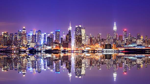 istock Water view of the Manhattan skyline at dusk with reflection 450564599