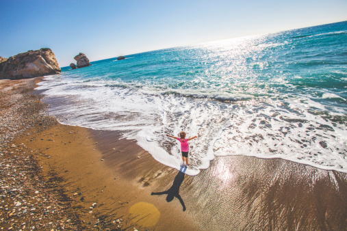 Girl standing at mediterranean beach.