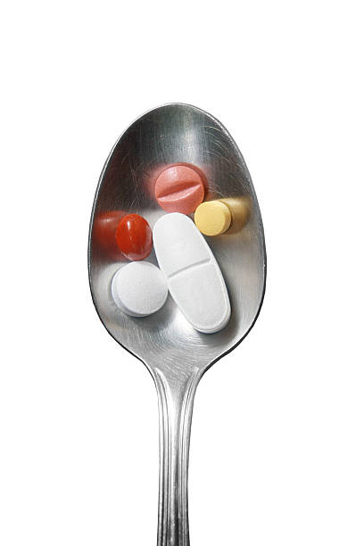 cucchiaio e pillole - capsule vitamin pill red lecithin foto e immagini stock
