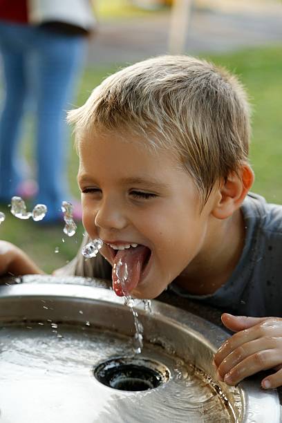 Happy child drinking water stock photo