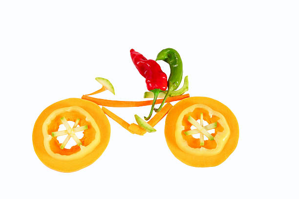 istock Healthy eating. Two little funny peppers on bicycle. 450605237