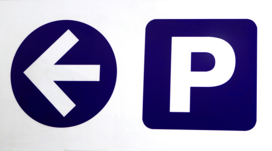 Parking Symbol with the letter P and an arrow pointing to the left. The symbol and arrow are isolated on white.