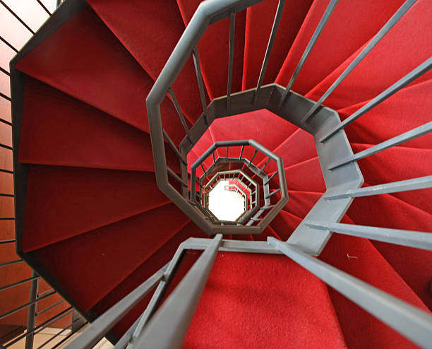 istock Iron spiral staircase with elegant red carpet 450636785