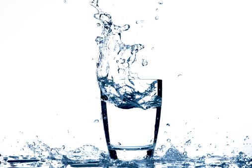 Water pouring to glass on white background