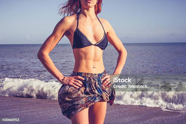 Young Woman With Toned Abs Standing On The Beach Stock Photo - Download Image Now - Abdominal Muscle, Adulation, Adult