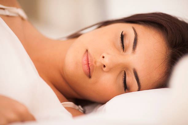 istock beautiful young woman sleeping on the bed 450660645