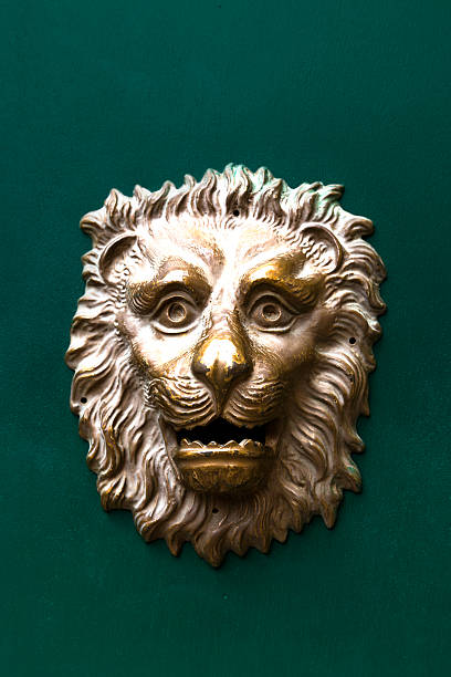 Golden lion mailbox against green wood background