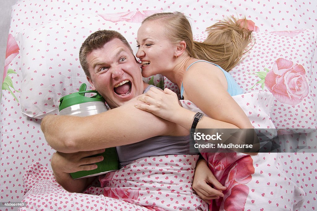 Menina leva guy barril de cerveja, deitada na cama - Royalty-free Abraçados na cama Foto de stock