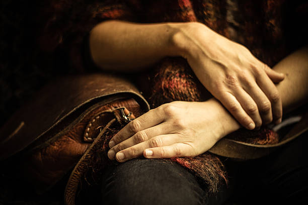 istock Woman with handbag sitting in dark room 450669237