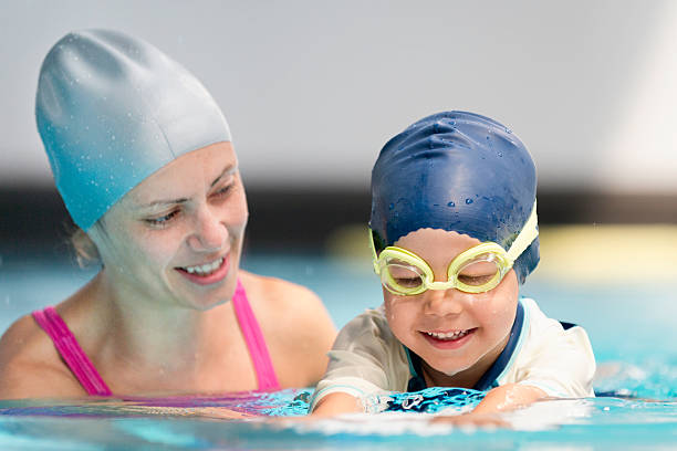 istock Female swimmer working with small boy learning to swim 450670605